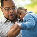 Black father holding toddler